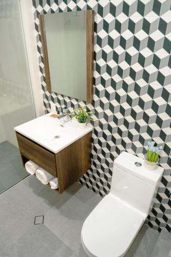 a bathroom with a sink and a toilet and a mirror at Hotel Tres Reinas in Xicotepec de Juárez