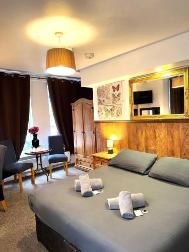a bedroom with two beds with towels on top of it at Riverside Hotel in Norwich