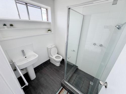 a bathroom with a shower and a toilet and a sink at Clean Bright Studio Apartment - Walkable Location in Melbourne