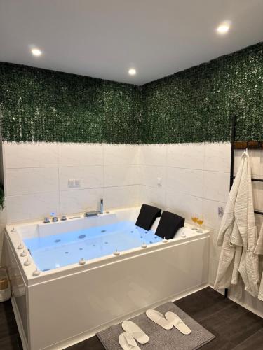 a tub in a bathroom with a green wall at Wood Spa Wellness Suite mit Whirlpool & Sauna nahe Göttingen in Rosdorf