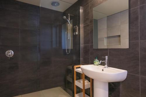 a bathroom with a white sink and a shower at Mapua Wharfside Apartments in Mapua