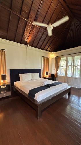 a large bed in a bedroom with a ceiling at Balangan Surf Resort in Jimbaran