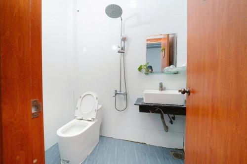 a bathroom with a sink and a toilet and a mirror at Hotel Tri Tôn in Tri Tôn