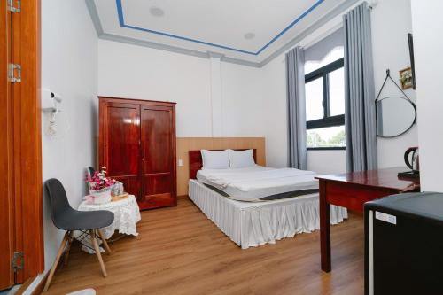 a bedroom with a bed and a desk in it at Hotel Tri Tôn in Tri Tôn