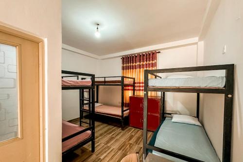a room with three bunk beds in a room at Kandy Golden Gate Resort in Kandy