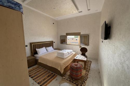 a small bedroom with a bed and a window at Riad Mifis in Rissani
