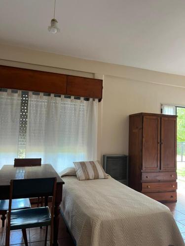a bedroom with a bed and a desk and a dresser at Casa Lavanda in Embalse