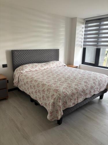 a bedroom with a large bed with a floral bedspread at Excelente, Exclusivo Depto en Pucón in Pucón