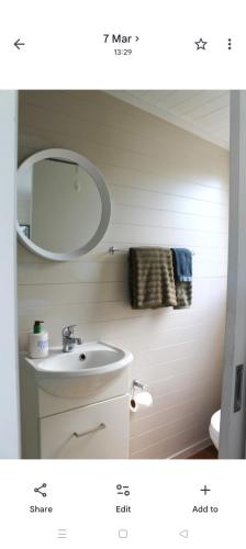 a bathroom with a sink and a mirror at Raglan park rest and stay cabins - Private studio in Raglan