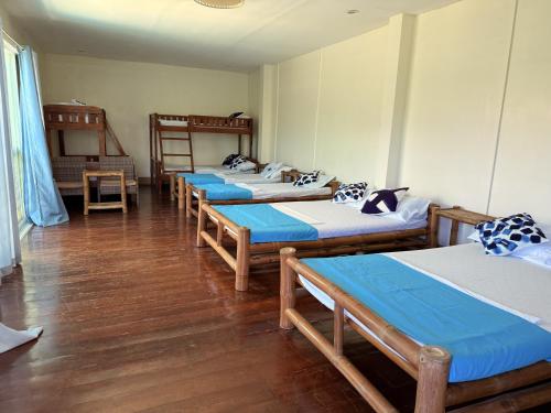 a group of four beds in a room at Blue Villa - Entire House with Private Pool in Panglao Island
