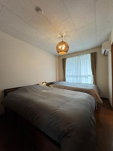 a bedroom with two beds and a window at BreakPoint in Ichinomiya