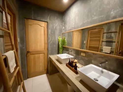 a bathroom with two sinks and a large mirror at Caba La Union Gulfside Cottage C3 in Caba