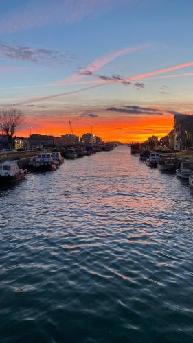 a river with boats in it at sunset at Fiumicino House Stay in Fiumicino