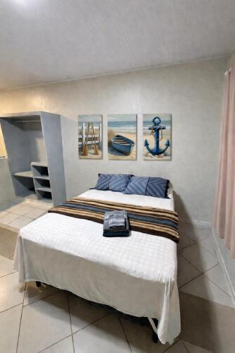 a bedroom with a bed and paintings on the wall at Aparthotel holandeses in São Luís