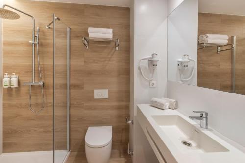 a bathroom with a shower and a toilet and a sink at B&B HOTEL Madrid Vallecas Ensanche in Madrid
