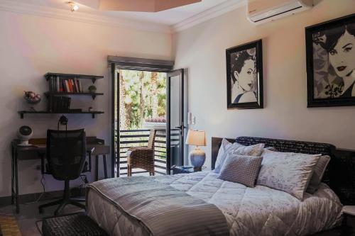 a bedroom with a bed and a desk and a window at Casas Blancas, Planta Alta in Todos Santos
