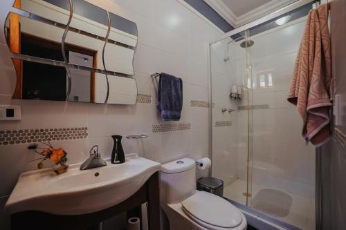 a bathroom with a toilet and a sink and a shower at Casas Blancas, Planta Alta in Todos Santos