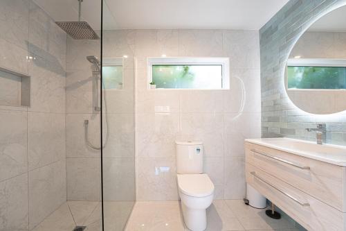 a bathroom with a toilet and a glass shower at Studio 17 Private Standalone Studio in Greenhithe North Shore in Auckland