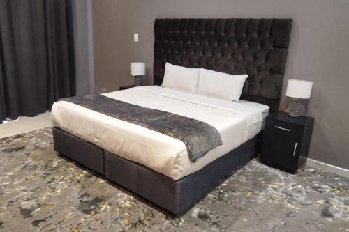 a large bed with a black headboard in a bedroom at Blueroof BYO in Bulawayo