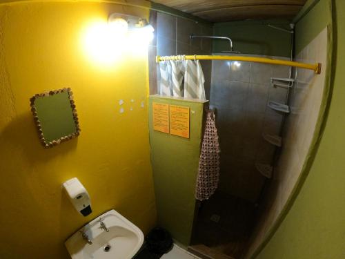 a small bathroom with a sink and a shower at Kamaq Hostel in Humahuaca