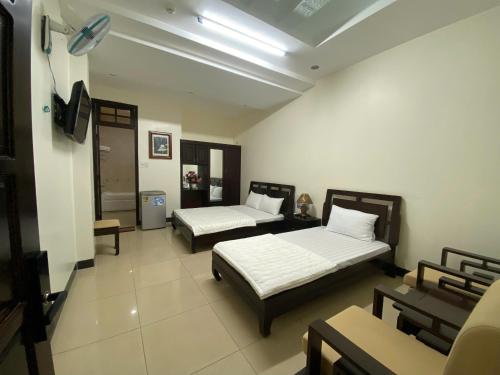 a bedroom with two beds and a tv in it at Khách Sạn Ninh Thọ in Quảng Ngãi
