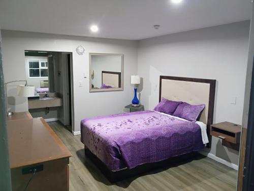 a bedroom with a purple bed and a sink at Bel Air Motor Lodge in Maple Shade