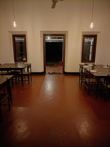 an empty room with tables and chairs in it at Thanayama Deniyaya in Deniyaya
