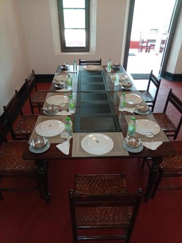 a long table with chairs and plates on it at Thanayama Deniyaya in Deniyaya