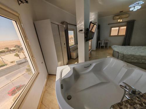 a large white tub in a room with a bedroom at Avrio Red Sea in Hurghada