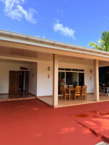 a house with a patio with a table and chairs at Fare Hinenao in Tevaitoa