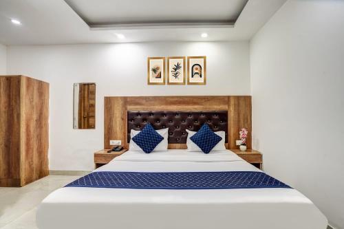 a bedroom with a large bed with blue pillows at Hotel IBY in New Delhi
