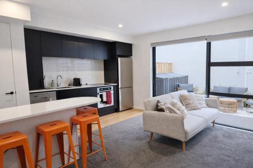 a kitchen and living room with a couch and a table at Luxury 2 Bed 2 Bath Townhouse Central Christchurch in Christchurch