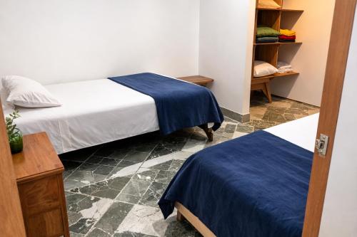 a room with two beds with blue sheets and a closet at Aparta Suites Torre de Prado 601 Apartamento para 9 Personas in Medellín