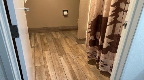 a hallway with a wooden floor and a door with a curtain at Antlers Inn in Chester