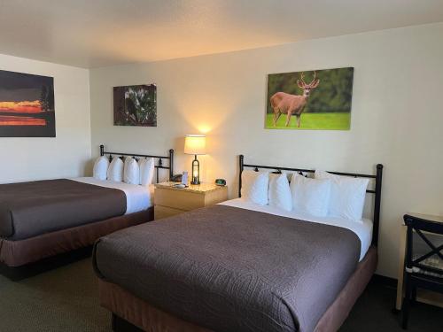 a hotel room with two beds and a deer on the wall at Antlers Inn in Chester