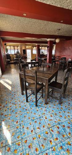 a restaurant with wooden tables and chairs on a blue carpet at EL MIRADOR dlr HR in Quetzaltenango