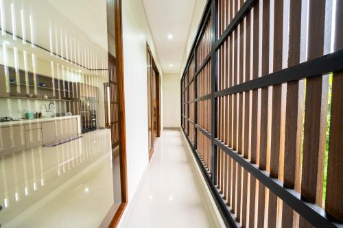 a hallway with wood and glass partitioning in a building at Dekade Living in Denpasar
