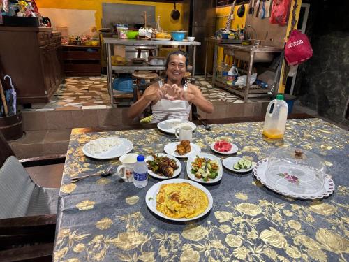 a woman sitting at a table with plates of food at Gio Private Villa - Langkawi in Langkawi Intl