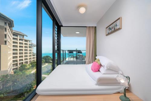 a bedroom with a white bed and a large window at Man Man hotel in Wutongkeng