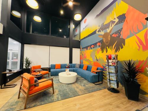 a living room with a blue couch and orange chairs at Quality Inn & Suites Thunder Bay Downtown in Thunder Bay