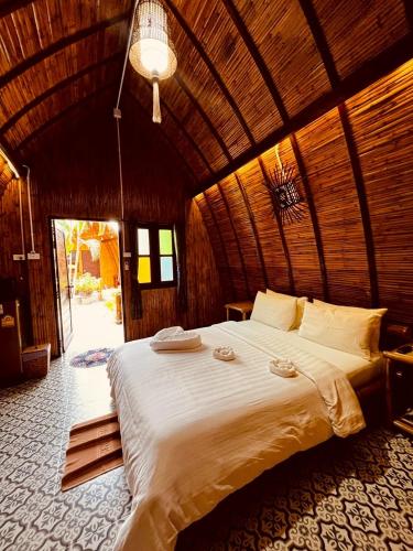 a bedroom with a large bed in a wooden room at Cicada Lanta in Ko Lanta
