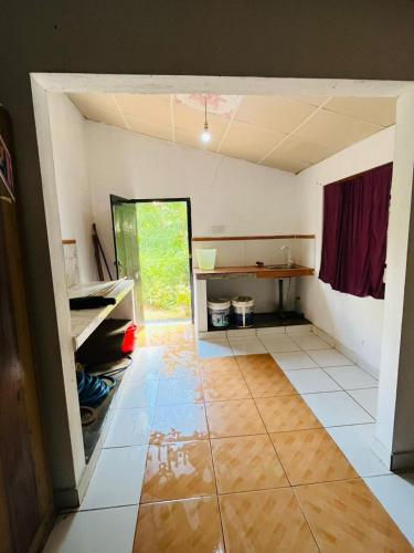 an empty room with a large room with a kitchen at Pudam Cottege in Kataragama