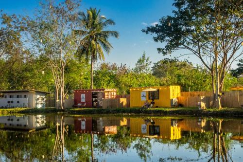 a group of houses next to a body of water at Lakeside Cargo in Yellow - A Cozy Container Stay in San Pa Tong