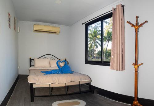 a bedroom with a bed with a cross on the wall at Lakeside Cargo in Yellow - A Cozy Container Stay in San Pa Tong