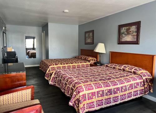 a hotel room with two beds and a chair at Oasis Inn and Suites in Fallon
