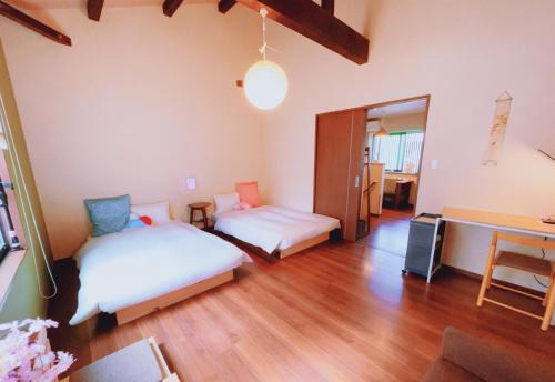 a room with two beds and a table in it at 桃夭庵 touyouan momo house kujo 一棟貸切 in Kyoto