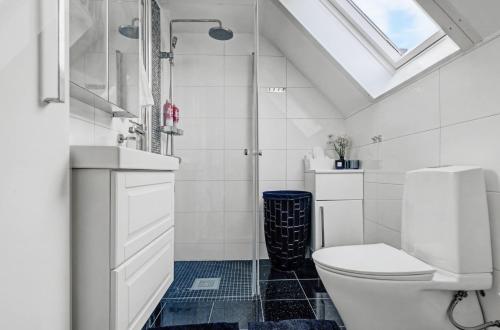 a bathroom with a toilet and a glass shower at Hambo Stay in Staffanstorp
