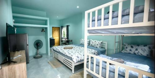 a bedroom with two bunk beds and a television at Koh Tao Townhouse in Ko Tao