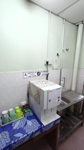 a kitchen with a sewing machine on a counter at Hotel Changlun B in Bukit Kayu Hitam