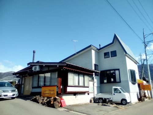 a white truck parked in front of a house at Guest House Honami-Kaido in Yamanouchi